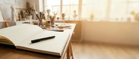 Open notebook with pen on wooden desk near window with warm sunlight, office supplies in background, workspace for writing, planning, creativity, education, business projects.