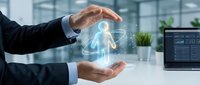 Businessman in dark suit holding glowing digital human figure hologram above hands at modern office desk with computer monitor and plants.
