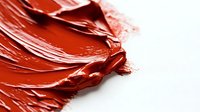 Vibrant red cosmetic cream texture with smooth glossy swatches showing rich pigment and creamy consistency against white background, macro photography closeup.