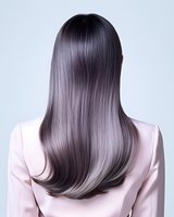 Back view of long straight silver grey ombre hair on Asian woman wearing light pink blazer, showcasing modern hair coloring technique and professional hairstyling.