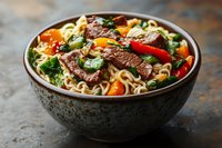 Asian noodle bowl with tender beef strips, colorful bell peppers, broccoli and carrots in savory sauce, served in rustic ceramic bowl on dark background.