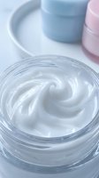 Luxurious white face cream with swirl texture in glass jar for anti-aging skincare routine and moisturizing treatment.