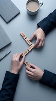 Two business professionals arranging wooden blocks with arrows on a desk, symbolizing strategy, direction, and teamwork in a corporate setting.