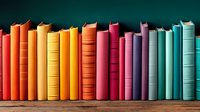 Colorful books arranged in rainbow spectrum order on wooden shelf against dark background, creating vibrant gradient from orange through pink to turquoise tones.