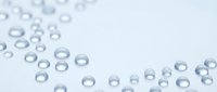 Clear water droplets scattered on clean white surface creating fresh minimalist composition for spa wellness beauty and hygiene concepts with copy space.