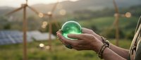 Hands holding glowing green sphere over sustainable solar panel farm at sunset representing renewable energy and environmental protection concepts.