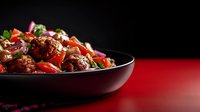 Spicy Asian stir-fried meat with colorful bell peppers and green onions served in black bowl against dramatic dark and red background. Food photography.