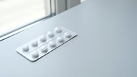 White medication pills in blister pack on clean surface for healthcare and pharmaceutical concepts.