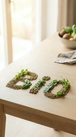 Word BIO made from lentils, seeds, and fresh green herbs on a wooden table, with a vegetable bowl in background, natural light.