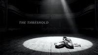 Exhausted performer lies on circular stage spotlight in dramatic black and white theatrical setting, conveying emotional intensity and artistic struggle.
