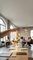 Hand protecting glowing lightbulb with network connections in modern office workspace symbolizing innovation and creative business ideas protection.