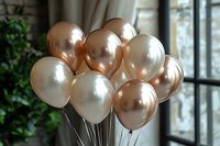 Elegant rose gold and pearl white metallic balloons bunch against window light, creating luxurious party atmosphere for wedding, birthday or celebration decor.