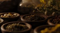 Aromatic dried herbs and spices in rustic wooden bowls on dark background, moody food photography composition for natural medicine and cooking.