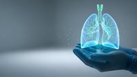 Glowing blue lungs floating above open palm representing respiratory health, medical care, pulmonary system protection and healthcare innovation concept.
