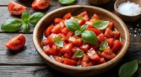 Fresh tomato basil salad in wooden bowl with herbs and sea salt on rustic table for healthy Mediterranean cooking and restaurant menu design.