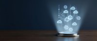 Cloud computing network emerging from glowing glass dome on wooden surface, representing data storage, digital infrastructure, and connected technology systems.