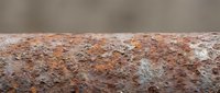 Close-up of weathered terracotta brick surface with aged patina, rust stains, and natural deterioration. Suitable for construction, architecture, and texture backgrounds.