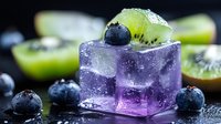 Purple ice cube with fresh kiwi slice and blueberries on dark background, water drops and melting ice create refreshing summer drink composition.