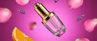 Luxury perfume bottle with golden cap floating among rose petals and orange slice on vibrant pink background for cosmetics advertising and beauty campaigns.