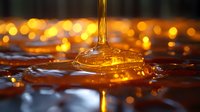 Liquid honey or golden oil pouring onto surface with warm bokeh lights, suitable for food, cosmetics, and wellness product marketing.