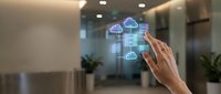 Hand touching holographic cloud computing interface with data analytics in modern office environment for digital transformation and technology solutions.