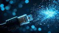 USB connector emitting glowing blue light particles, symbolizing high-speed data transfer and digital connectivity in modern technology.