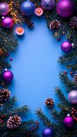 Christmas frame with purple and blue baubles, lit candles, pine cones and fir branches on blue background. Festive winter holiday border design with copy space.