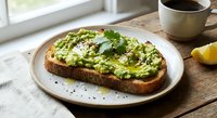 Avocado toast with herbs and feta cheese on sourdough bread served on white plate with coffee cup, healthy breakfast meal for morning dining and nutrition.