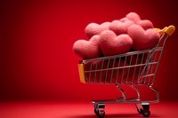 Shopping cart filled with red hearts on vibrant red background for Valentine's Day love romance retail marketing campaigns and seasonal promotions.
