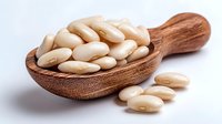 White kidney beans in wooden spoon on white background. Nutritious legumes for healthy cooking and plant-based protein source.