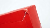 Red cracked surface with white lightning-like fractures showing damage and weathering effects on painted material for design projects.