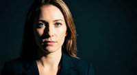 Professional businesswoman with confident expression against dark background for corporate marketing and leadership concepts.