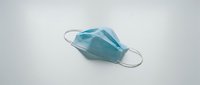 Single blue surgical face mask with elastic ear loops isolated on white background, ready for healthcare, medical, and safety design projects.