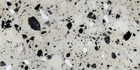 Black and white speckled terrazzo texture with natural stone aggregate pattern on polished concrete surface creates modern architectural background.