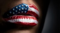 Close-up of female lips painted with stars and stripes flag pattern in red white and blue colors for patriotic makeup concept and national pride expression.