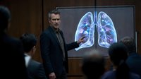 Middle-aged Caucasian male doctor presenting lung anatomy on digital screen to medical students in modern classroom setting for healthcare education.