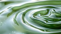 Swirling green liquid creates mesmerizing abstract ripples and waves in macro photography, showing fluid dynamics and natural patterns in motion.
