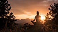 Person meditating in lotus position during golden hour sunset with mountain landscape and silhouetted trees creating peaceful mindfulness scene.