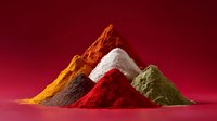 Vibrant piles of colorful spice powders arranged as mountains against dark red background, featuring turmeric, paprika, curry and other exotic cooking seasonings.
