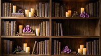 Cozy wooden bookshelf with vintage books, glowing candles and purple flowers creating warm atmospheric home library interior for reading nook design.