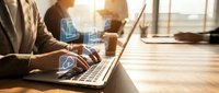 Professional businesswoman working on laptop with digital document icons in modern office environment during golden hour sunlight.