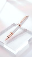 Elegant fountain pen with rose gold accents and white barrel resting on minimalist white platform. Luxury writing instrument for stationery, office, and lifestyle design projects.