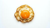 Crispy fried egg with golden yolk and lacy edges isolated on white background for breakfast menu design and culinary projects.