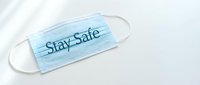 Blue disposable medical face mask with Stay Safe text on white background, health protection and pandemic safety concept.
