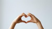 Hands forming heart shape gesture against white background expressing love, care and affection for romantic concepts and emotional wellness campaigns.