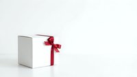 White gift box with red ribbon bow on white background, suitable for holiday promotions, e-commerce product displays, and festive marketing materials.