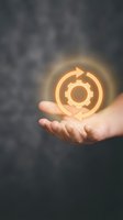 Hand holding glowing gear and arrow icon symbolizing continuous improvement, process optimization, and business development strategy for corporate growth.