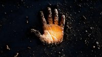 Glowing handprint in scattered flour on dark background creates mysterious atmospheric composition with warm light emanating from center. Suitable for cooking concepts.