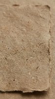 Natural adobe clay brick with rough textured surface and earthy brown color for construction and architectural projects.
