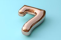 Metallic rose gold number seven on light blue background, glossy balloon-like digit with reflective surface. Suitable for typography and celebration designs.